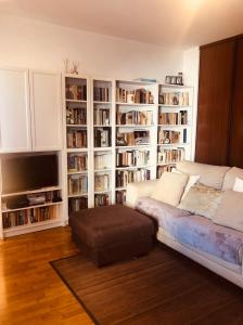 a living room with a couch and book shelves at Casa da Aldeia - Guest House in Odiáxere
