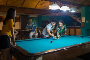 a group of people playing a game of pool at Playa Tropical Resort Hotel in Currimao