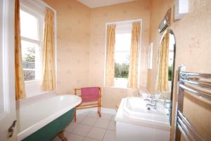 a bathroom with a tub and a sink at Bonawe House Holiday Cottages in Taynuilt