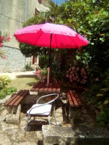 a pink umbrella sitting next to a bench with a chair at Apartment Castel in Bale