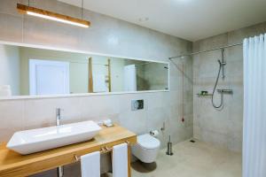 a bathroom with a sink and a shower and a toilet at Vila Baleira Village in Porto Santo