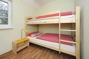 Ein Etagenbett oder Etagenbetten in einem Zimmer der Unterkunft Bauernhofferien Schild Fewo Strand