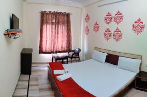 Un dormitorio con una cama y una silla y una ventana. en Madhav Guest House, en Jaipur