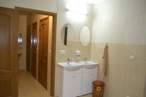 ein Badezimmer mit einem Waschbecken und zwei Spiegeln an der Wand in der Unterkunft Tonal in Mukatschewo
