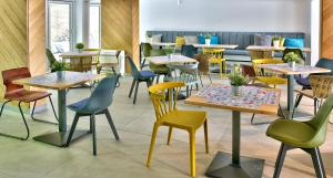 a room with tables and chairs in a restaurant at ibis Styles Golden Sands Roomer Hotel in Golden Sands