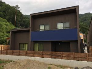 a brown house with a blue roof at Villa Orange Cabin in Fujikawaguchiko