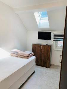 Hideaway Obertraun في اوبرترون: غرفة نوم مع سرير وتلفزيون على خزانة
