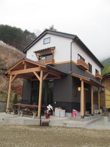 a house with a picnic table in front of it at Villa Orange Cabin in Fujikawaguchiko