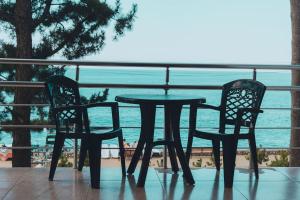 a table and two chairs on a balcony with the ocean at Hotel Solidarity in Kobuleti