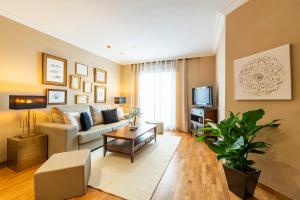 uma sala de estar com um sofá e uma televisão em Abastos Apartment Center em Valência