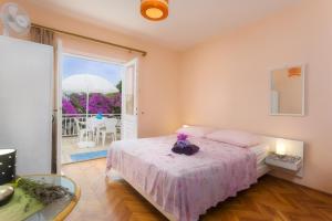 een slaapkamer met een bed en een patio met een parasol bij Aras Wind Rose in Supetar