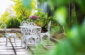 2 sillas blancas y una mesa en el patio en Avemore Wag n Bietjie No 1 en Stellenbosch