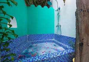 um chuveiro com azulejos azuis e um chuveiro com efeito de chuva em The Seyyida Hotel and Spa em Zanzibar