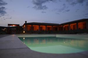 a swimming pool in front of a building at night at Residence Le Casine in Batignano