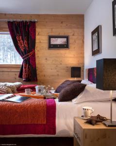 Un dormitorio con 2 camas y una mesa con comida. en CGH Résidence Boutique Le Lodge des Neiges en Tignes