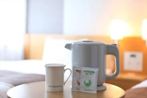 una macchinetta del caffè e una tazza sul tavolo di Hotel Hokke Club Oita a Oita