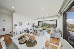 a dining room and living room with a table and chairs at Vila Papagaio Verde by An Island Apart in Funchal