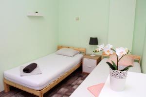 a small room with a bed and a vase with flowers at Central Charming Home with Garden near Parking and NDK in Sofia