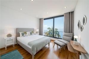 um quarto com uma cama e vista para o oceano em Vila Papagaio Verde by An Island Apart no Funchal