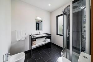 une salle de bain blanche avec un lavabo et une douche dans l'établissement Vila Papagaio Verde by An Island Apart, à Funchal 41 autres photos