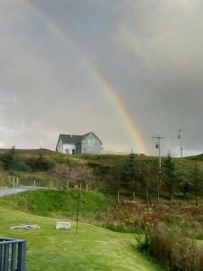 a rainbow over a house on a hill at Garroch House in Carbost