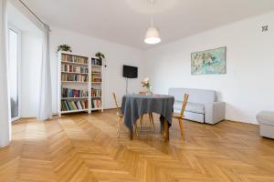 ein Esszimmer mit einem Tisch und Stühlen im Wohnzimmer in der Unterkunft Royal Route Apartment for 10 people in Warschau