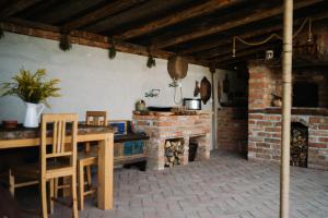 cocina con mesa y chimenea de ladrillo en La Mama Anica en Porumbacu de Sus