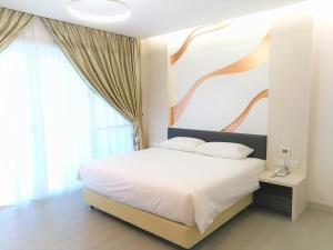 a bedroom with a bed with a painting on the wall at Legacy Hotel Ipoh in Ipoh