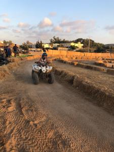 a person riding a quad bike on a dirt road at Appart Clim Wifi 700m de la Plage in Saïdia