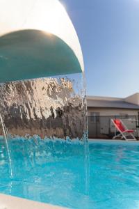 una fuente de agua en una piscina en The Originals City, Hôtel Les Dômes, Perpignan Sud Saleilles, en Perpiñán
