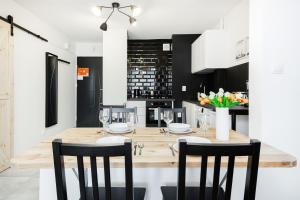 a dining room with a wooden table and chairs at First Central Apartments by Renters in Warsaw