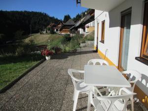 Una mesa blanca y sillas al costado de un edificio. en Ferienwohnung Maria, en Todtmoos