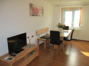 a living room with a television and a table with chairs at Ferienwohnung Maria in Todtmoos
