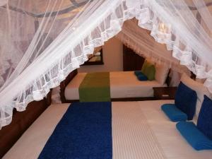 2 letti in una camera con baldacchino di Suriya Homestay Mirissa a Mirissa