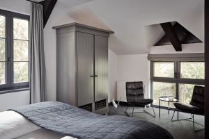 a bedroom with a bed and two chairs at Landhaus Flottbek Boutique Hotel in Hamburg