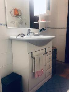 a bathroom with a sink and a mirror and towels at Casa da Aldeia - Guest House in Odiáxere +42 photos