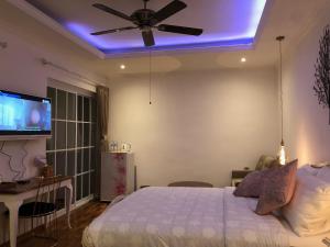 a bedroom with a bed with a ceiling fan and a tv at Villa Hikari Bali in Seminyak