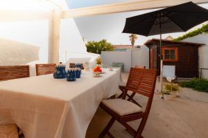 a table with a white table cloth and an umbrella at Casa en Primera Línea de Playa in Oliva