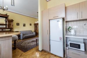 uma cozinha com um frigorífico e uma sala de estar em George Apartment em Lviv