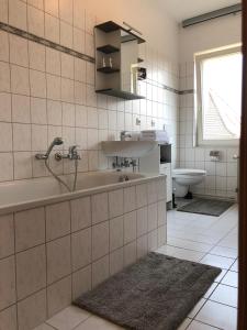 een badkamer met een bad, een wastafel en een toilet bij Viadrina Rooms & Apartments Frankfurt-Oder am Park im Zentrum in Frankfurt/Oder