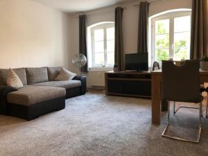 a living room with a couch and a table with a tv at Viadrina Rooms & Apartments Frankfurt-Oder am Park im Zentrum in Frankfurt Oder