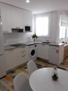 科爾多瓦的住宿－Noches de Azahar，厨房配有白色橱柜和桌椅