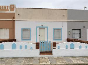 a building with a blue chair in front of it at Casa en Primera Línea de Playa in Oliva