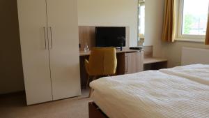 a bedroom with a bed and a desk with a television at Wartmannstetterhof in Wartmannstetten