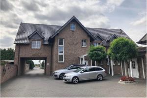a brick house with two cars parked in front of it at Haus Schönewald in Dormagen