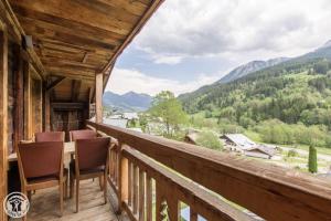 a balcony with chairs and a view of mountains at Chalet la griotte in Abondance