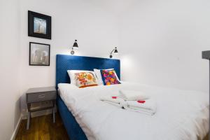 una camera con letto blu e bianco e comodino di Independence Museum Charming Apartment a Varsavia