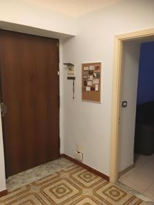 a room with a brown door and a hallway at VegApartment in Catania