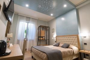 um quarto com uma cama, uma mesa e uma janela em Brunelli B&B em Assis