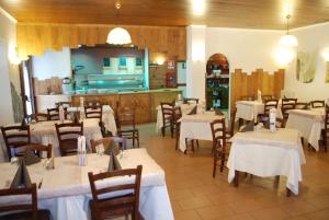 a restaurant with tables and chairs and a kitchen at Hotel Delle Alpi in Sondalo